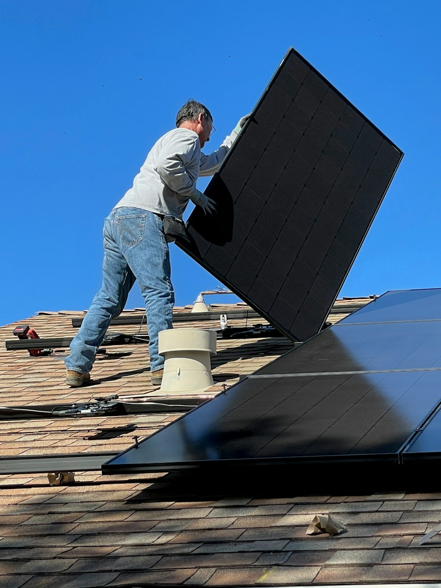Un installateur pose un panneau solaire sur un toit